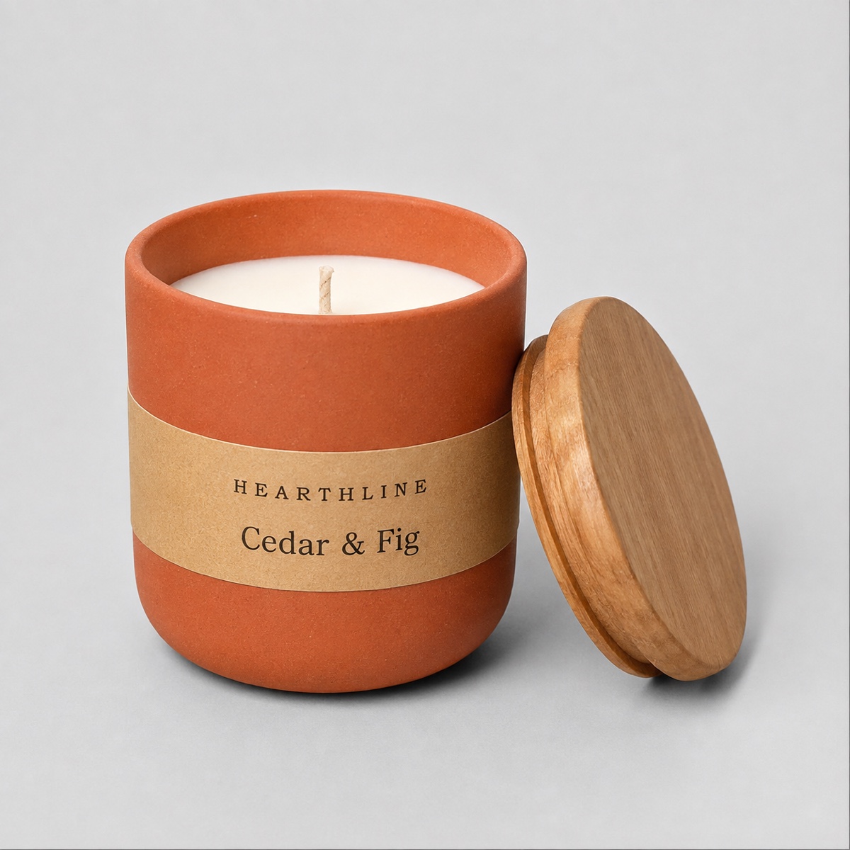 A soy candle in a glass jar photographed on a plain background