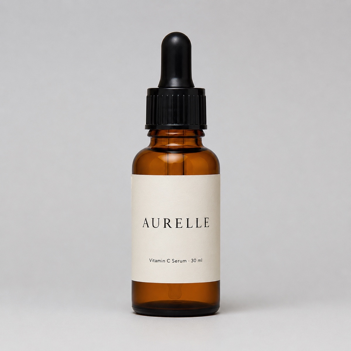 A vitamin C serum bottle photographed straight on against a plain grey background