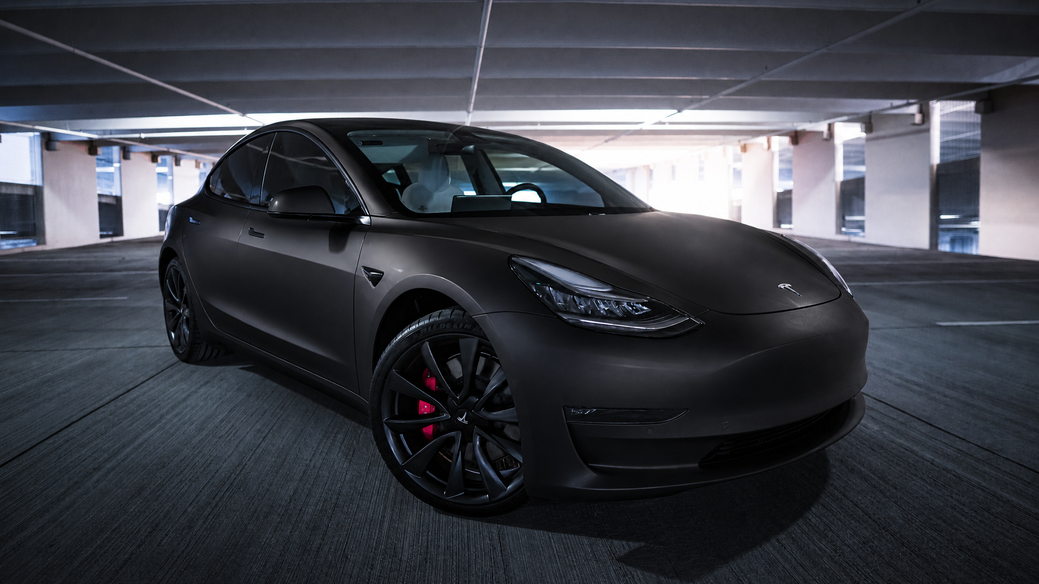 The same sedan re-rendered in a satin black wrap by the ModMyCar studio